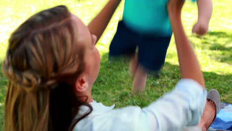 madre bonita jugando con su hijo bebé lindo en la manta de picnic