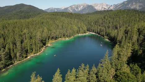 Explorando-Un-Hermoso-Lago-Cristalino-Rodeado-De-Imponentes-Pinos-Sensación-De-Libertad-Y-Alegría-Verdadero-Hogar-Hábitat-Natural-Cielo-En-La-Tierra-Grandes-Montañas-Al-Fondo-Vista-Cinematográfica-Muy-Alta