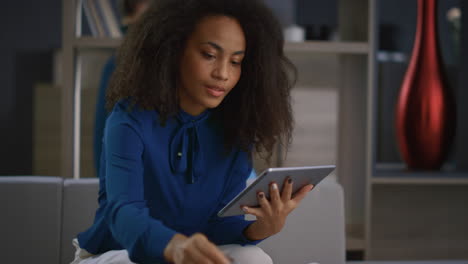 Calm-african-american-entrepreneur-woman-work-tablet-drink-coffee-in-home-office