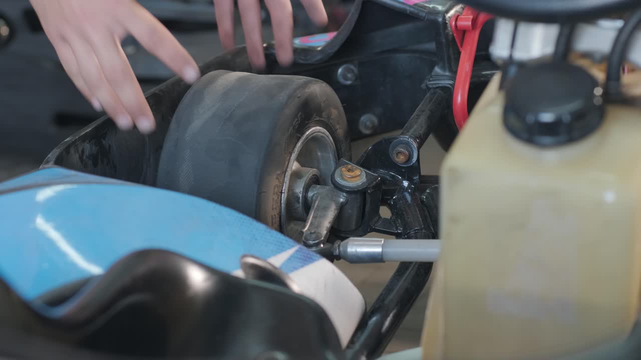 el mecánico del servicio de carreras de go kart cambia las ruedas