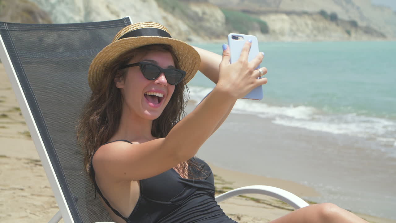 mujer tomando un selfie en la playa