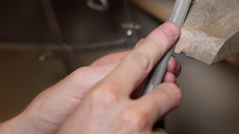 Jeweller-filing-gold-ring-in-his-workshop