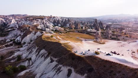 la antena vuela lateralmente durante la hora dorada en el valle de kizilcukur, göreme, capadocia