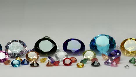 diamantes de colores de varios tamaños brillando sobre un fondo blanco.