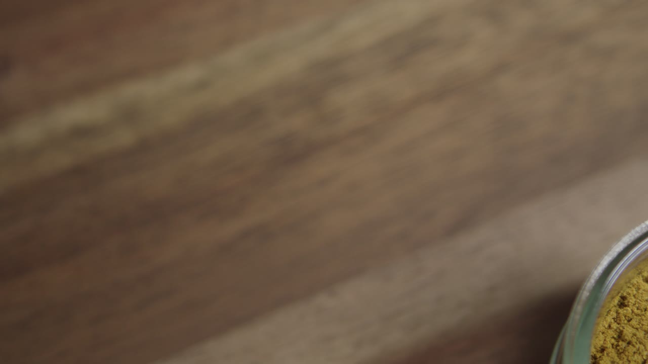 disparo cercano medio de polvo de curry sentado en un pequeño frasco de vidrio