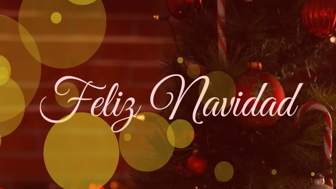 animación de manchas amarillas de luz y pancarta de texto feliz navidad contra un árbol de navidad decorado.