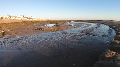 low tide turns seawater into a flowing river from the beach to the sea, gulf of california, rocky point, puerto peñasco, mexico