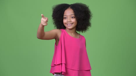 young cute african girl with afro hair pointing finger
