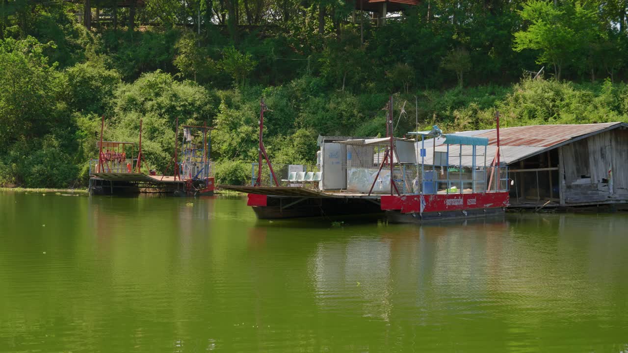 tiro de casas flotantes a lo largo de la orilla del lago en el pueblo de pescadores de pak nai, provincia de nan, tailandia con vegetación verde en el fondo durante el día