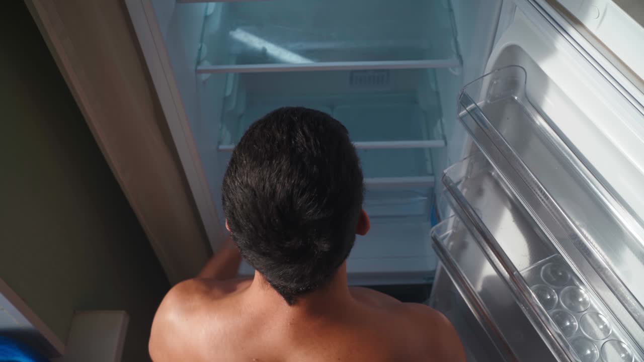 사람이  빈 냉장고를 열고 경제 위기와 빈곤에 대한 개념