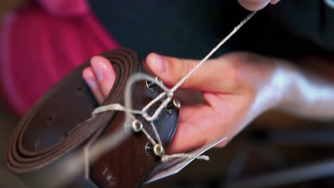 women-untie-a-fine-thread-knot-of-a-leather-belt
