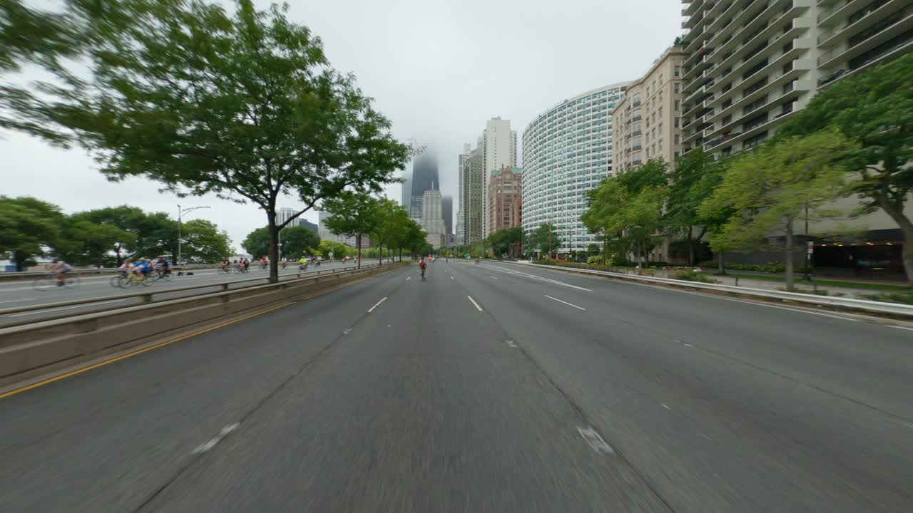 Chicago cyclists riding southbound on DuSable Lake Shore Drive during Bike the Drive 2022 magnificent mile skyscrapers clouds overcast