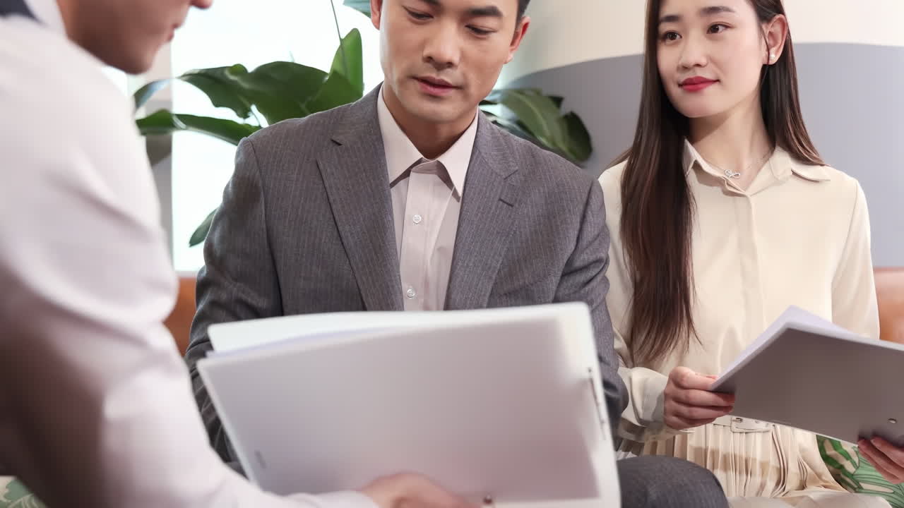 成功した2人のビジネスマンが契約書に署名し、交渉会議で合意を交わす。パートナーが握手する様子。