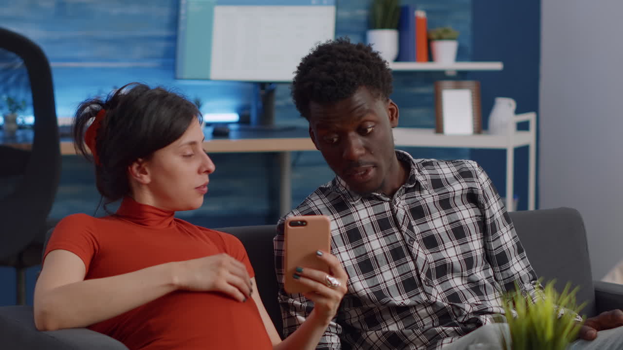 Married interracial couple relaxing on living room sofa