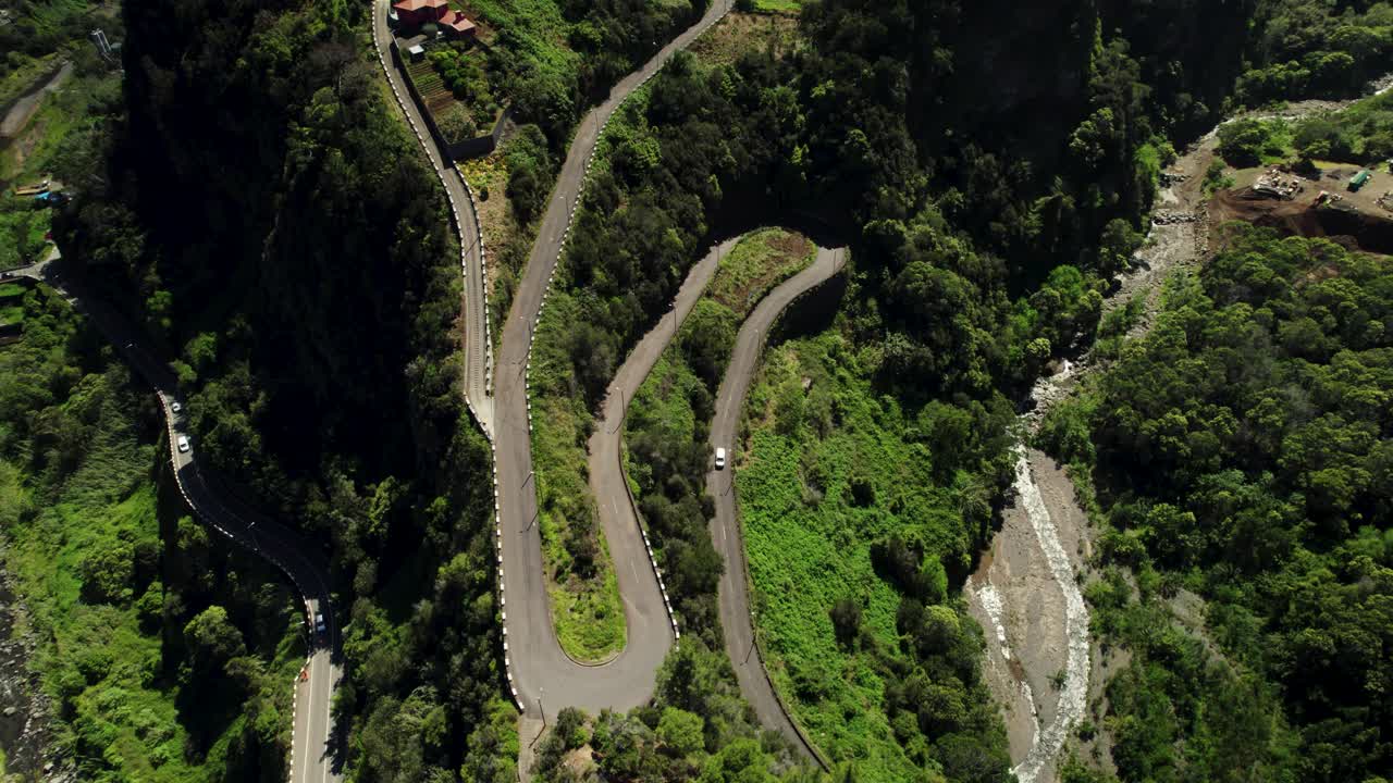 imágenes de drones de la curva de la carretera empinada en las montañas verdes en un día soleado