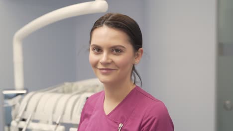 Dentist-female-doctor-removing-surgical-mask-and-smiling-to-the-camera,-portrait-shot