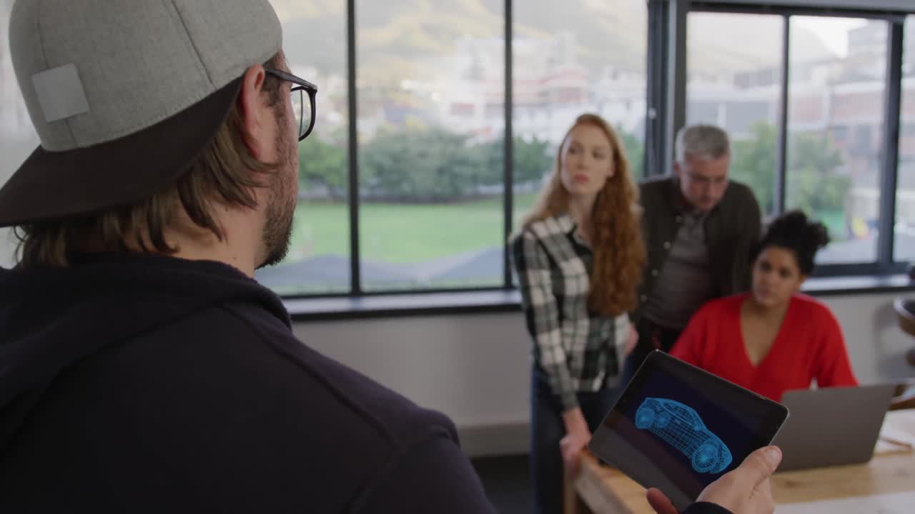 hombre caucásico hablando con colegas en una oficina creativa