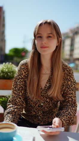 una mujer joven relajándose en un café al aire libre.