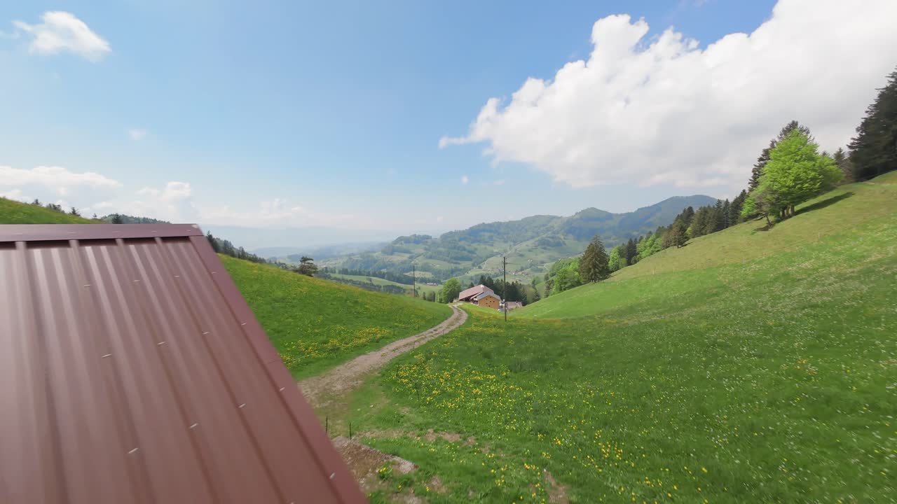 Rolling green hills and a dirt path through a scenic mountainous landscape