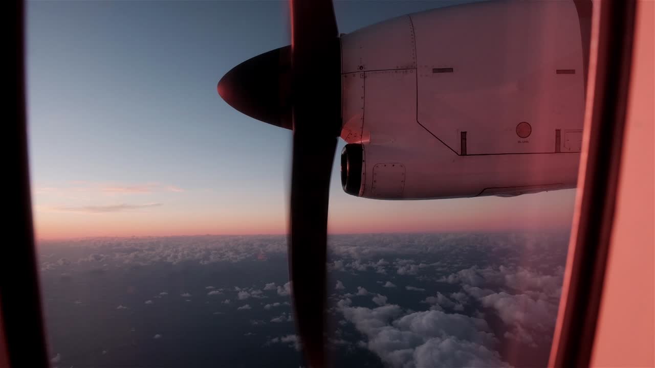 hélice de un pequeño avión a través de la ventana de un avión en vuelo en el crepúsculo