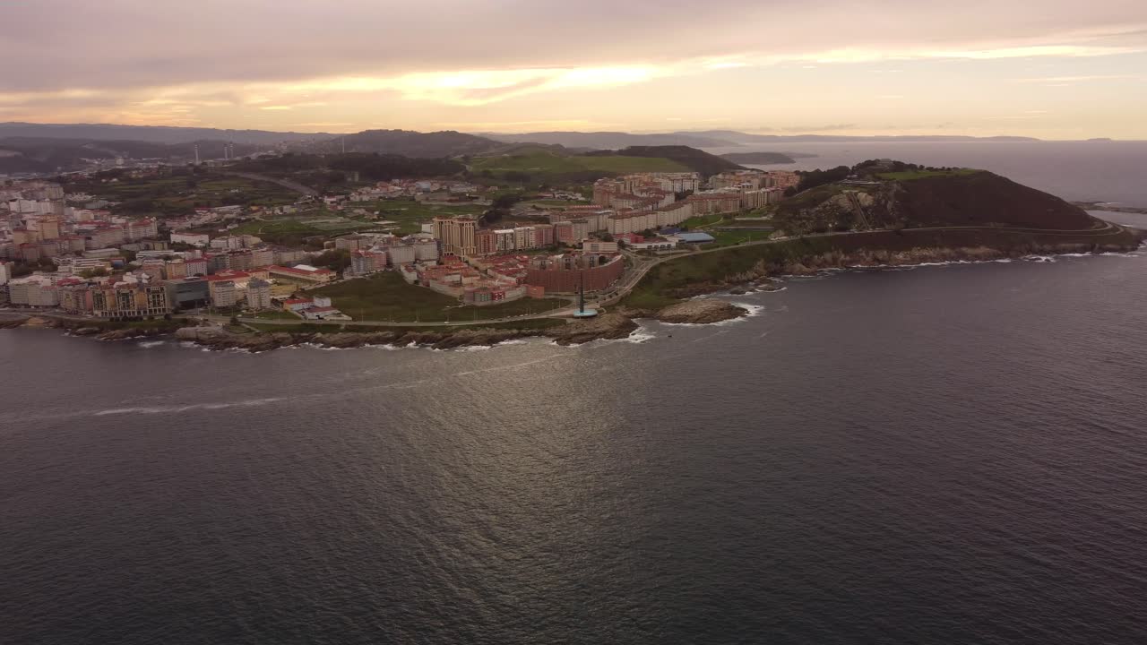 Riprese aeree panoramiche del paesaggio urbano di La Coruña durante un tramonto nuvoloso.