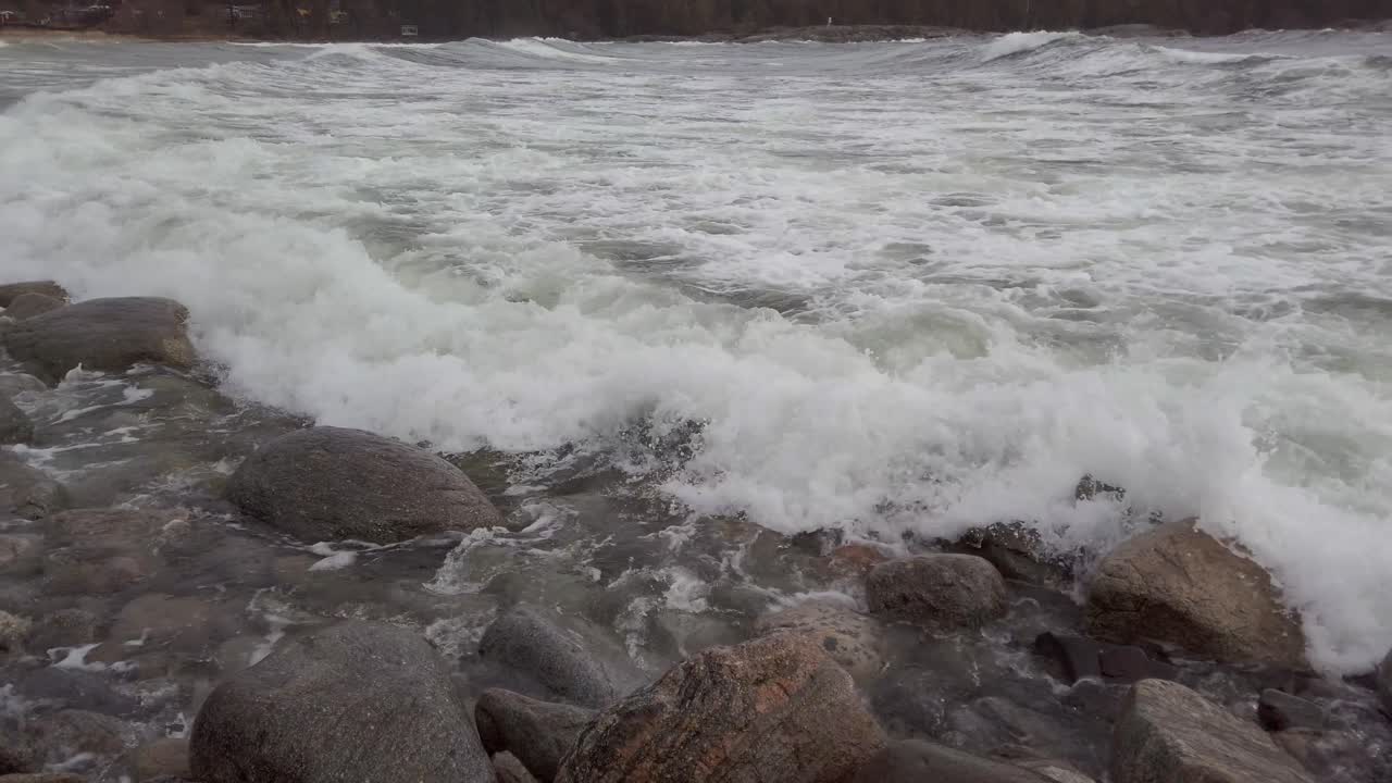 Waves washing over rocks panning left