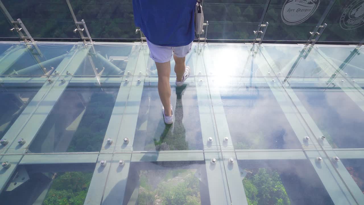 자연 속의 사람은 유리 테라스를  ⁇ 고 있습니다.