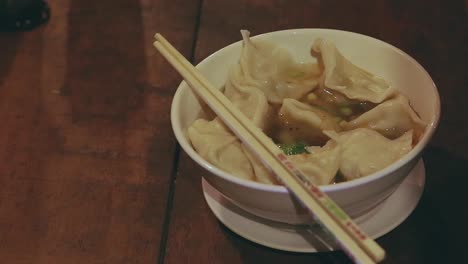 tasting the broth of a traditional khmer dumpling noodle soup called mii kiev and siev mai, authentic cambodian dish