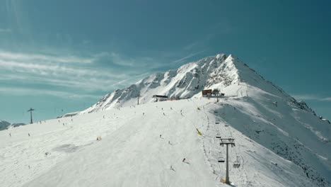 chairlift on ski slopes on snow-covered mountains, aerial drone view