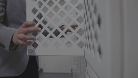 man in suit opens a locker in dressing room