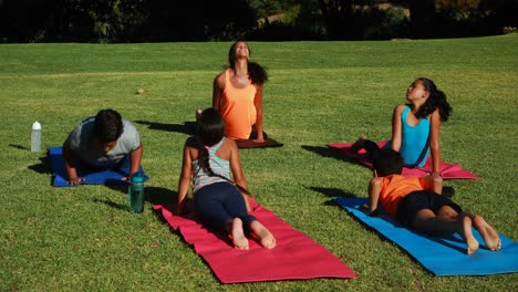 yoga instructor instructing children in performing exercise