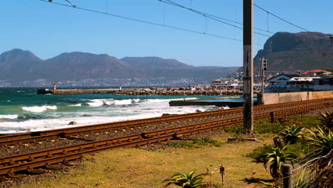 vista del puerto de kalk bay desde las viejas vías del tren, olas rompiendo en la orilla