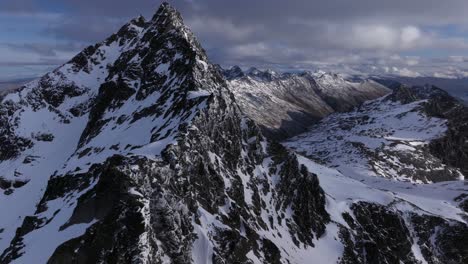 Wild-rugged-rocky-and-snowy-mountains-on-beautiful-day-with-blue-skies-and-rolling-clouds