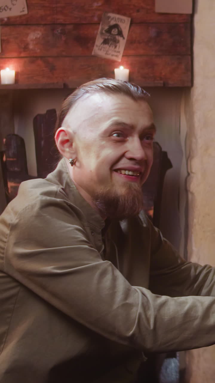 los viajeros ven a un compañero en la taberna. hombre borracho feliz de conocer a un extraño mientras el compañero enojado sienta a un amigo en una casa de huéspedes medieval. performance de fantasía