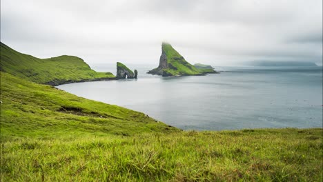 stunning smooth water crashes on tindholmur mountain in the faroe islands, surrounded by lush green hills and dramatic cliffs