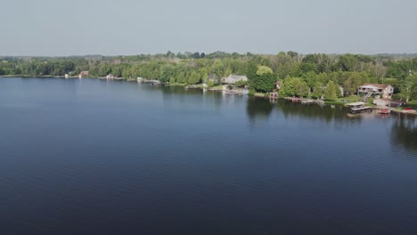 panning on coastal resort town with dense trees reflecting in serene ocean