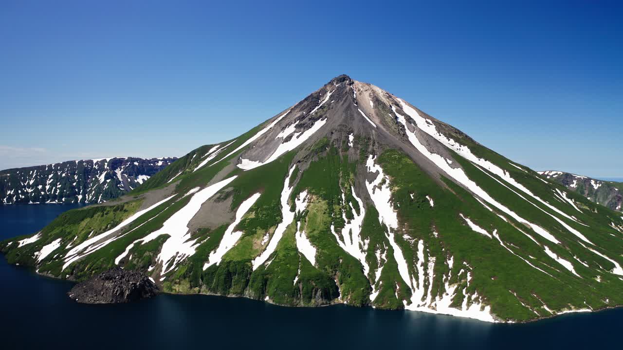 glorioso panorama aéreo. cono volcánico verde y blanco, agua azul a su alrededor, soleado