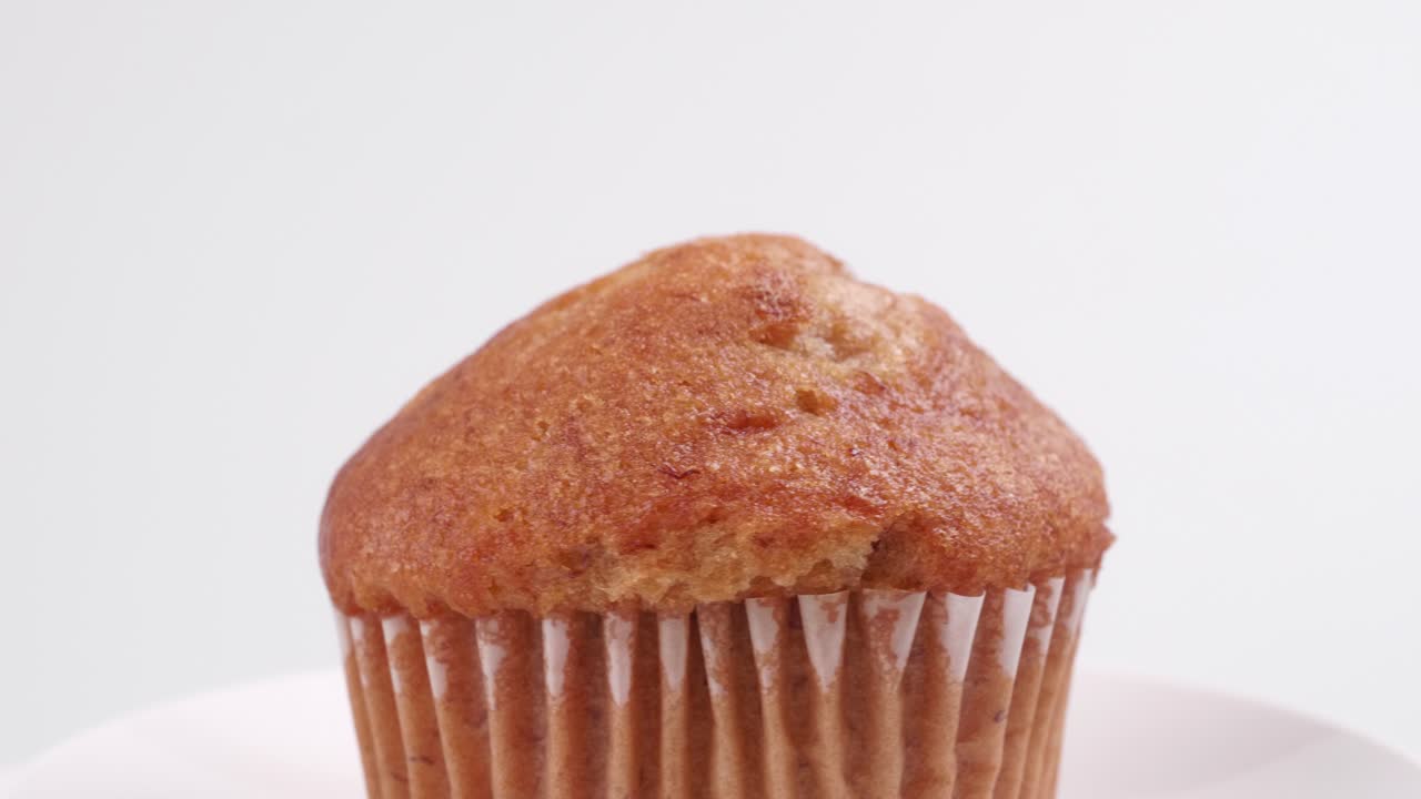 흰색 배경에 얕은 포커스가 있고 천천히 회전하는 머핀 바나나