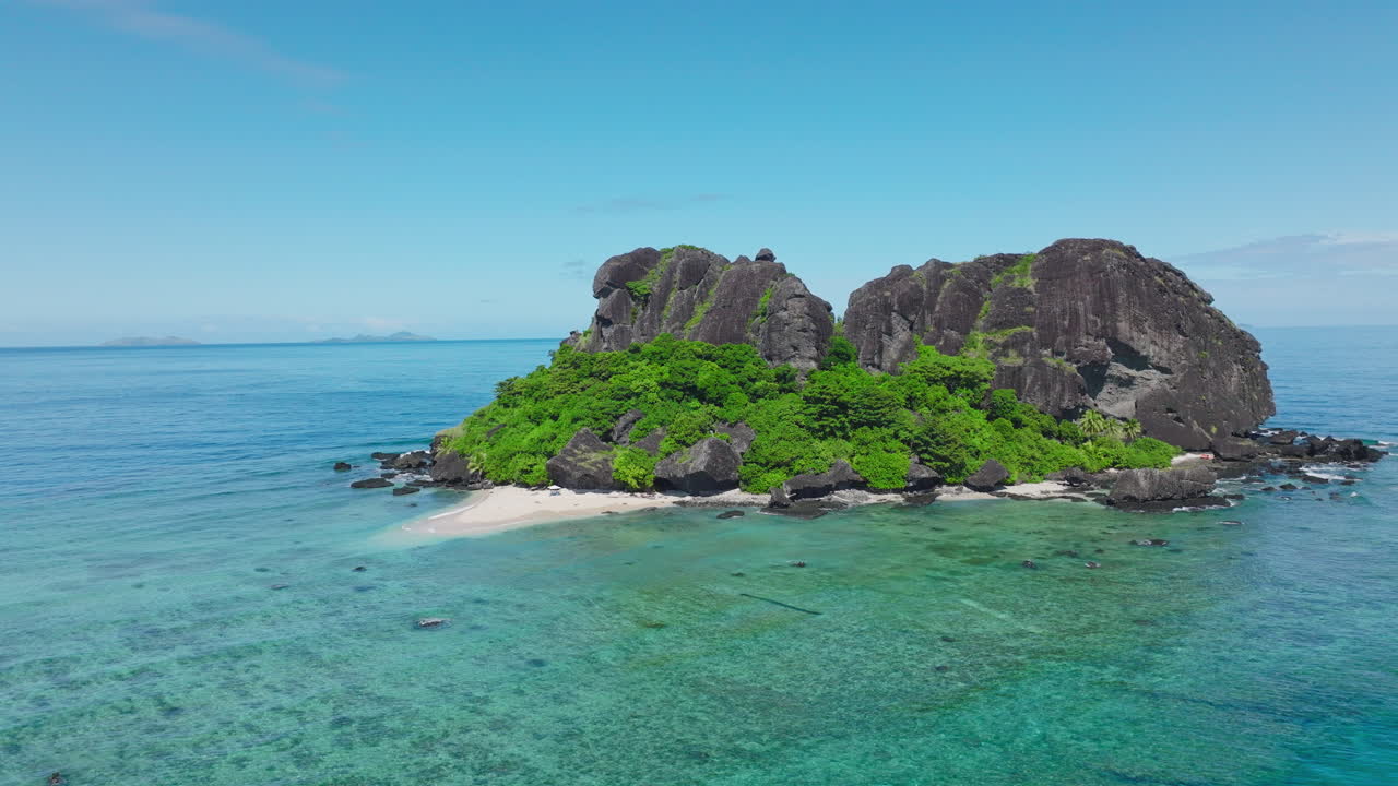 Isolated island with reef on bright blue ocean surface in South Pacific