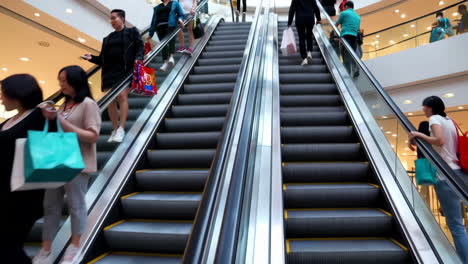 people using escalators in a bustling shopping mall