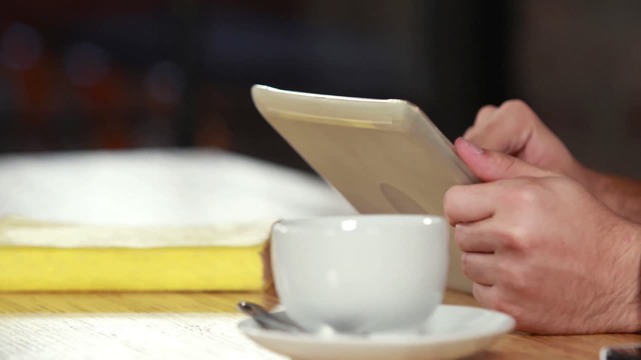 Close up hipster man scrolling on a tablet