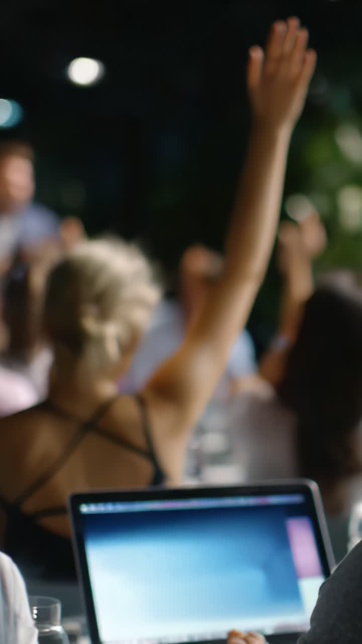 Interazione dinamica in classe: partecipanti coinvolti che alzano le mani in un ambiente di apprendimento collaborativo incentrato sulla discussione e sulla partecipazione