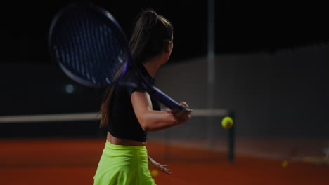 woman playing tennis at night