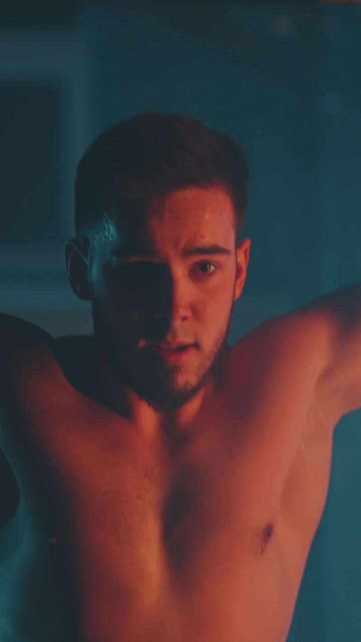 Uomo concentrato si prepara per il sollevamento pesi in una palestra con illuminazione suggestiva