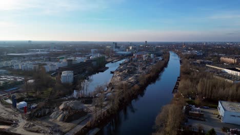 berlin biogas plant with its large white tanks reflecting on the river next to it during sunset. lovely aerial view flight overflight flyover drone