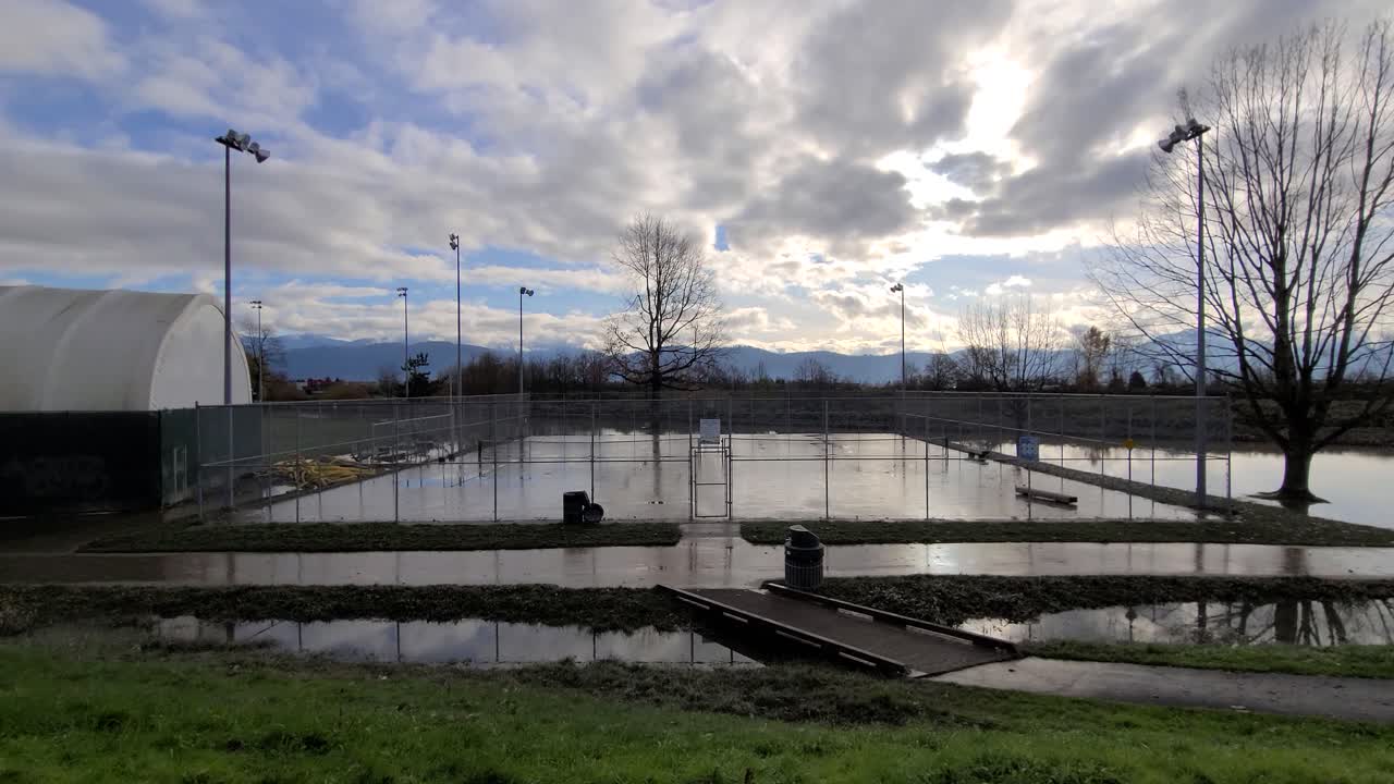 낮에는 흐린 하늘과 촉촉한 야외 테니스 코트의 전망