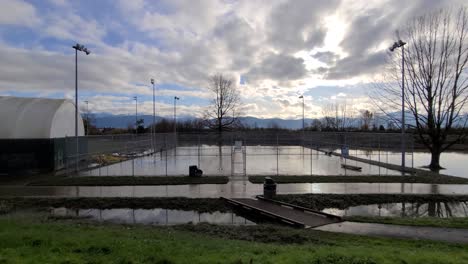 view of the cloudy sky and moisty outdoor tennis court during the day