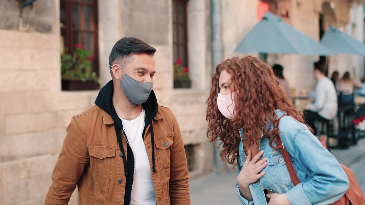 팔꿈치로 서로 인사 마스크를 쓰고 빨간 머리 여자와 백인 남자