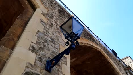 Rotating-shot-of-a-lamp-on-the-side-of-the-exterior-walls-of-the-Tower-of-London