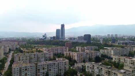 drone shot, flying down on a bright summer day in sofia, bulgaria, looking at the only skyscrapers in the city